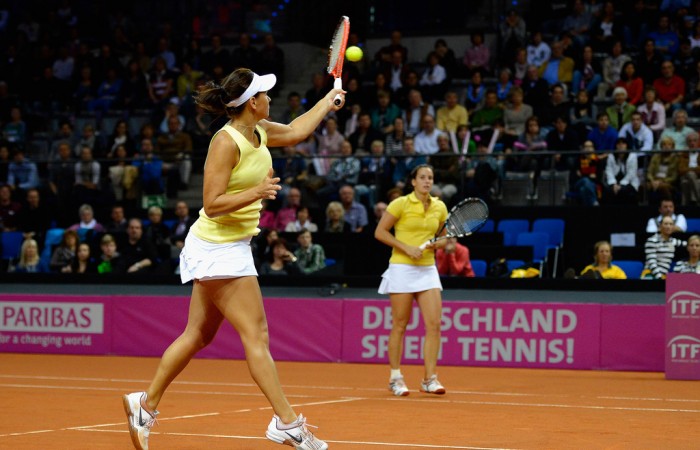 Casey Dellacqua plays a forehand as partner Jarmila Gajdosova watches on; Getty Images