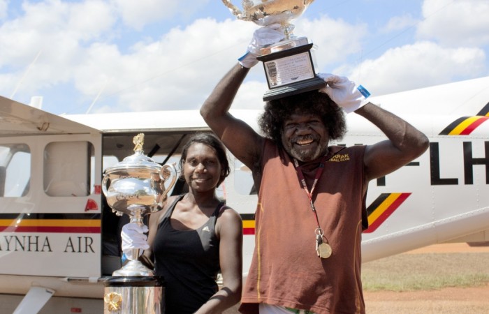 Aboriginal elder Gurramin Marika and his daughter pose with the Australian Open trophies at Laynhapuy Aviation station; Tennis Australia