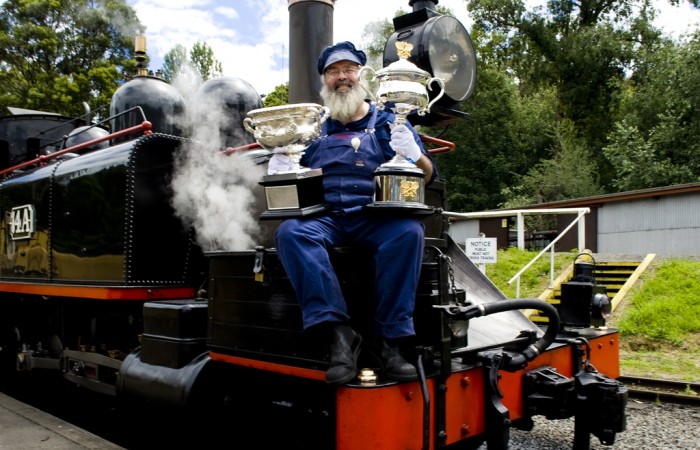 Puffing Billy train driver Gary poses with the Australian Open trophies as part of the Australian Open trophy tour's stop in Belgrave, Victoria; Bek Johnson