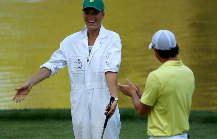 Rory McIlroy of Northern Ireland applauds caddie and girlfriend Caroline Wozniacki as she tries her hand with the clubs during the Par 3 Contest prior to the 2013 US Masters at Augusta National Golf Club; Getty Images