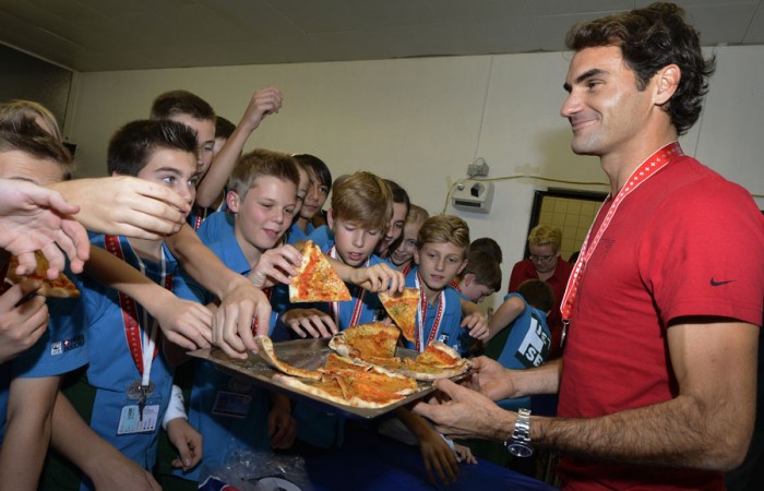 Switzerland's Roger Federer offers slices of pizza to ball kids after the Swiss Indoors ATP tennis tournament final match in Basel on October 27, 2013. Federer lost to Argentina's Juan Martin del Potro 7-6(3) 2-6 6-4. The Swiss, who worked as a ball boy in Basel, traditionally offers pizza at the end of the tournament; Harold Cunningham/AFP/Getty Images