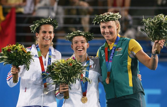 ATHENS - AUGUST 21:  (L-R)  Amelie Mauresmo of France (silver), Justine Henin-Hardenne of Belgium (gold) and Alicia Molik of Australia (bronze) wave to the crowd during the medal ceremony for the women's singles tennis event on August 21, 2004 during the Athens 2004 Summer Olympic Games at the Olympic Sports Complex Tennis Centre in Athens, Greece. (Photo by Clive Brunskill/Getty Images)