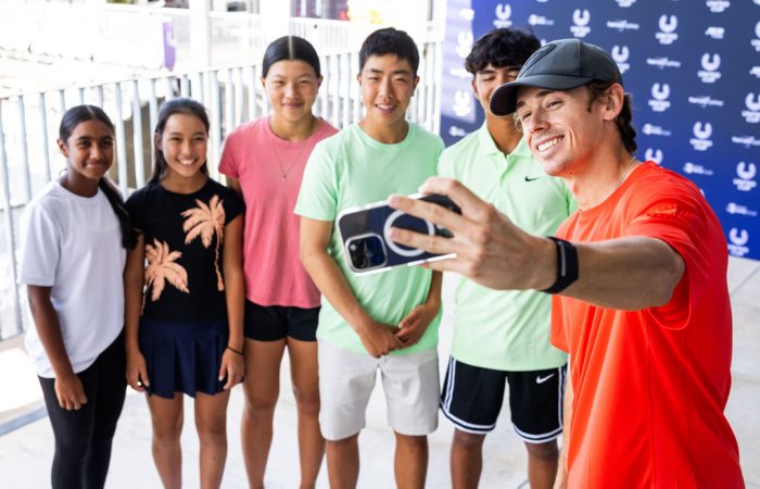 Alex de Minaur shares a special moment with scholarship participants.